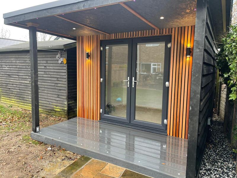 Green Room Gardens - garden room at dusk with cedar cladding and wall lights