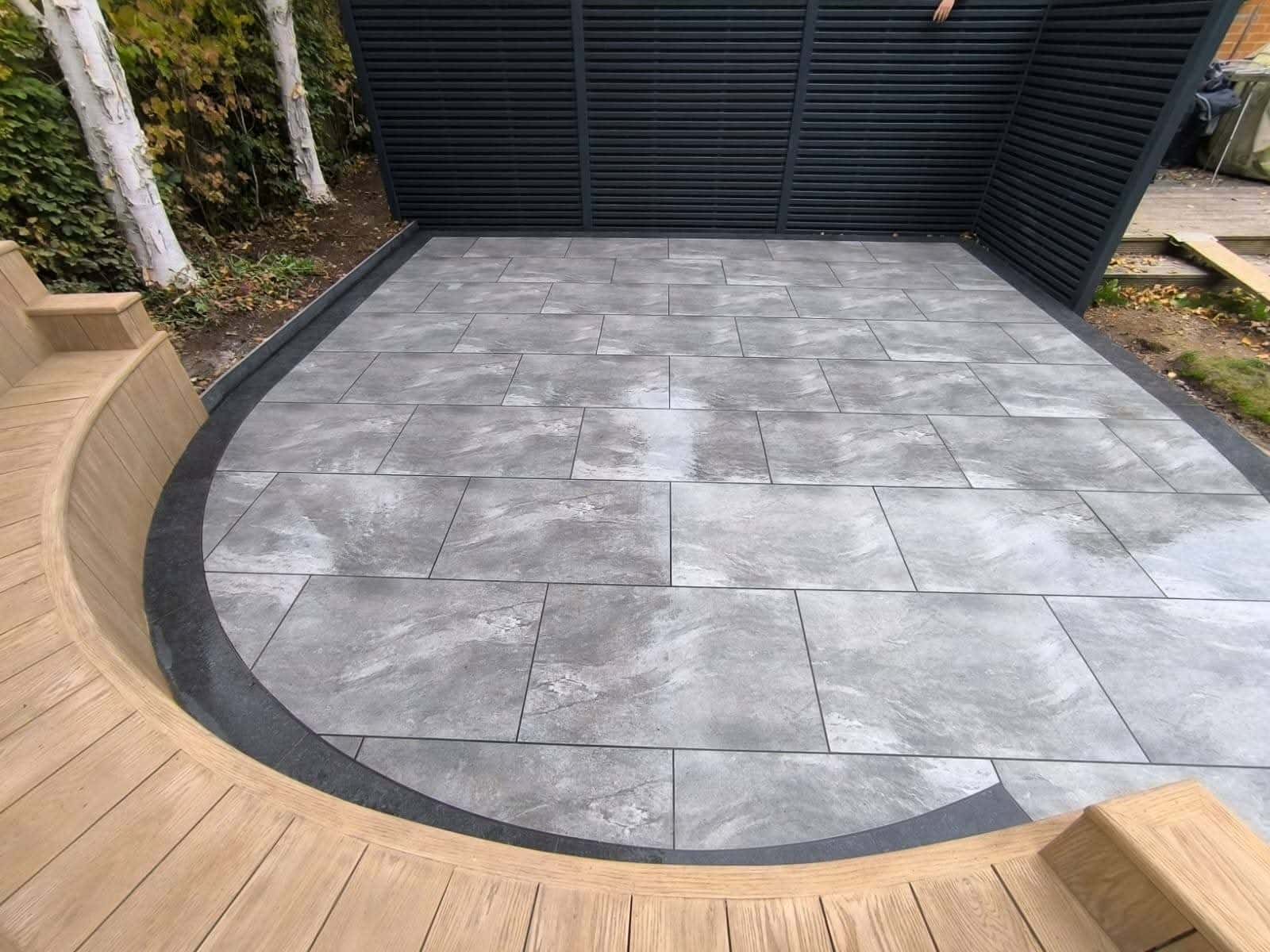 Green Room Gardens - grey porcelain circular patio feature with timber decking border