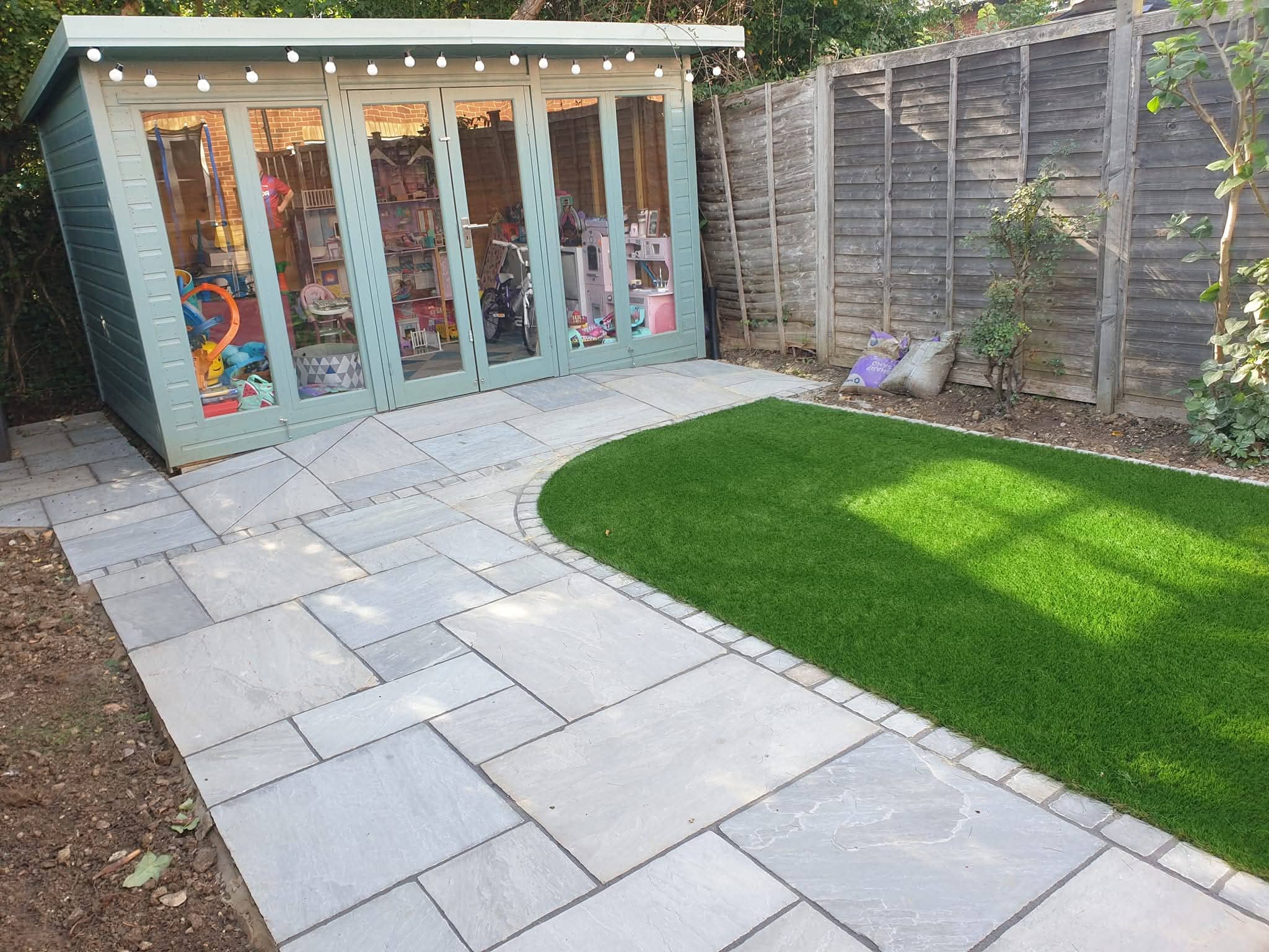 Green Room Gardens - large porcelain patio with artificial grass and pergola