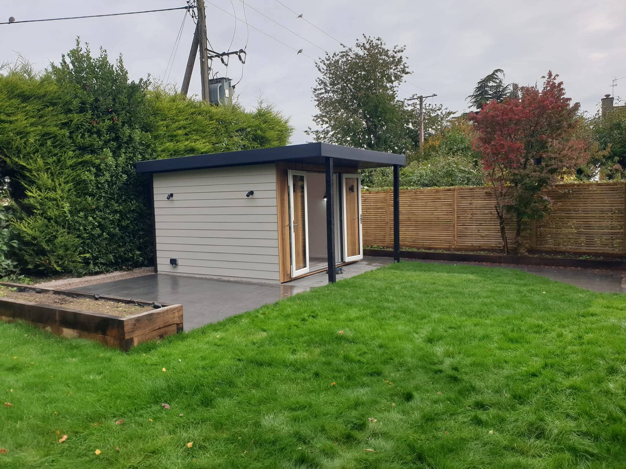 Green Room Gardens - grey garden building with artificial grass and timber fencing