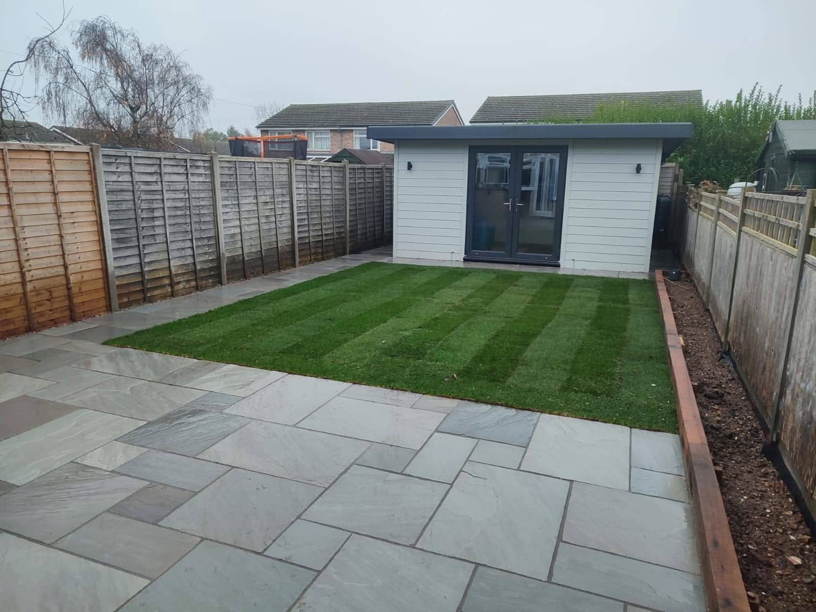 Green Room Gardens - artificial grass with porcelain stepping stones and sleeper edge